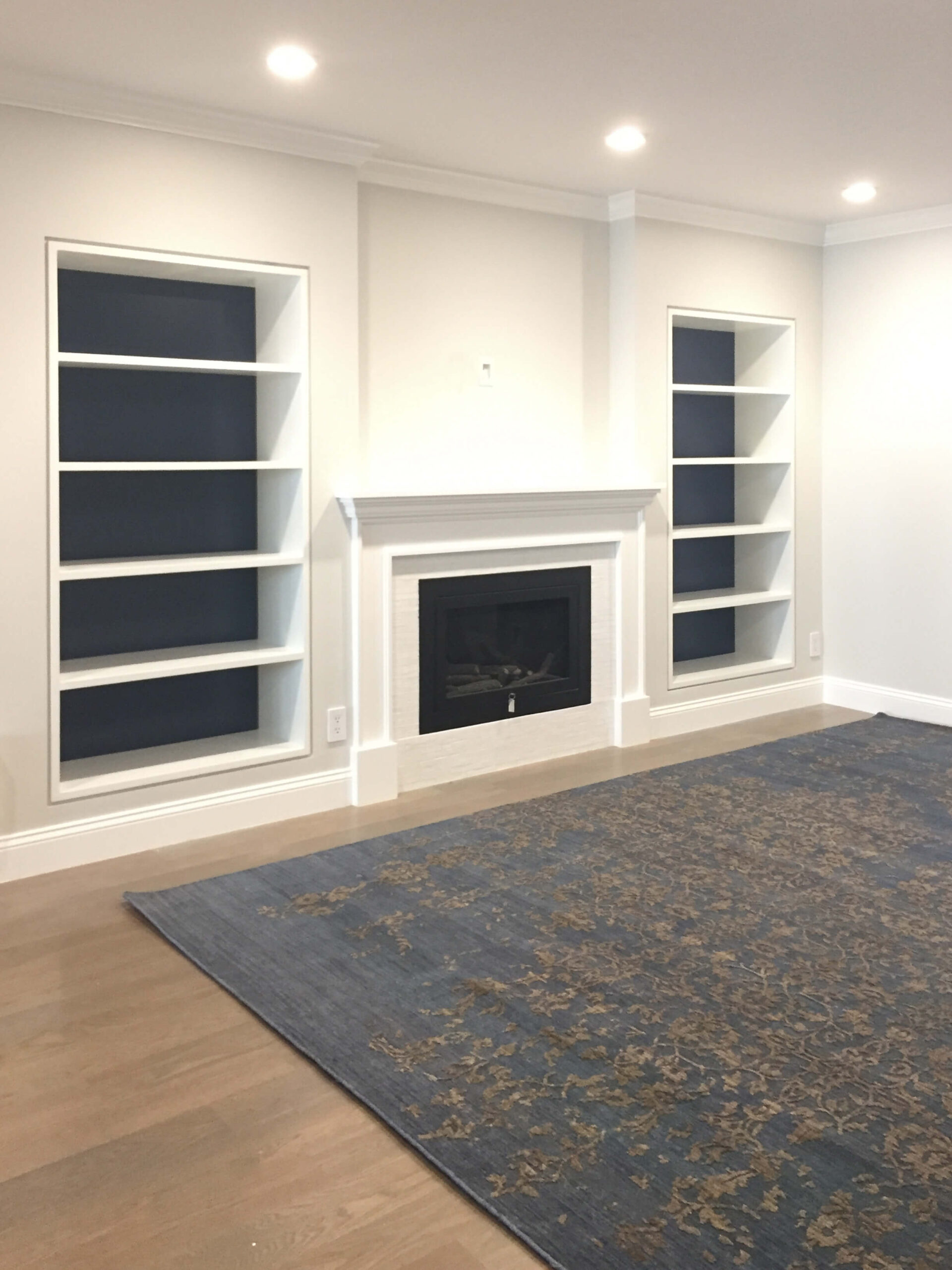 transitional blue rug , custom home , custom bookshelves , accent color in the bookcase , full house renovation , home renovation