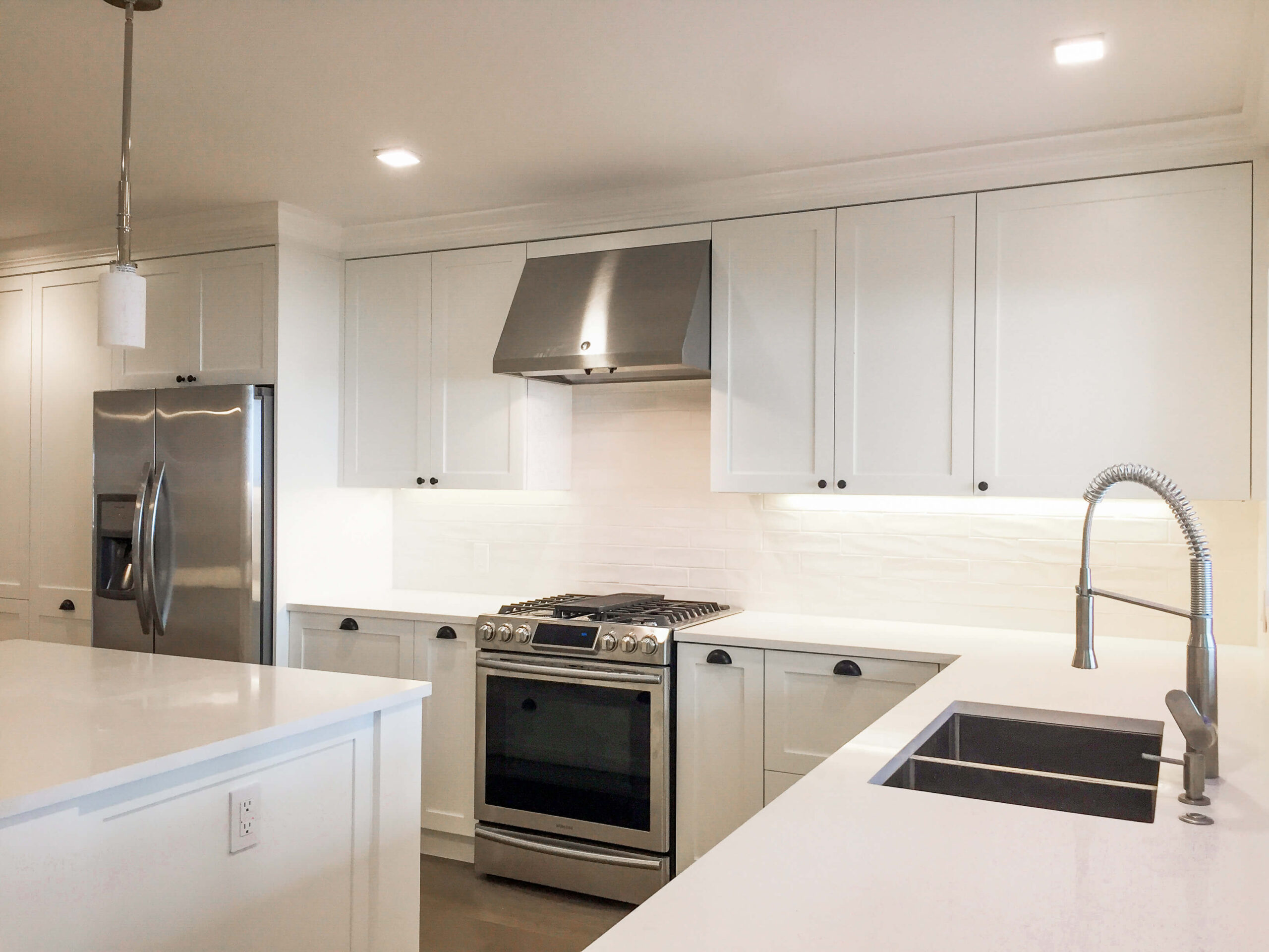 white quartz countertop, white shaker cabinetry, contemporary kitchen , white backsplash tile , full house renovation , home renovation