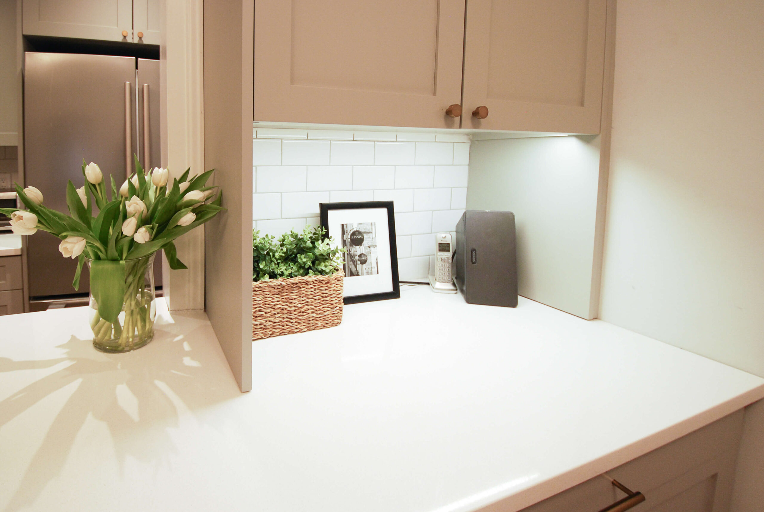 white quartz countertop, colored shaker cabinetry, transitional kitchen , white subway backsplash tile