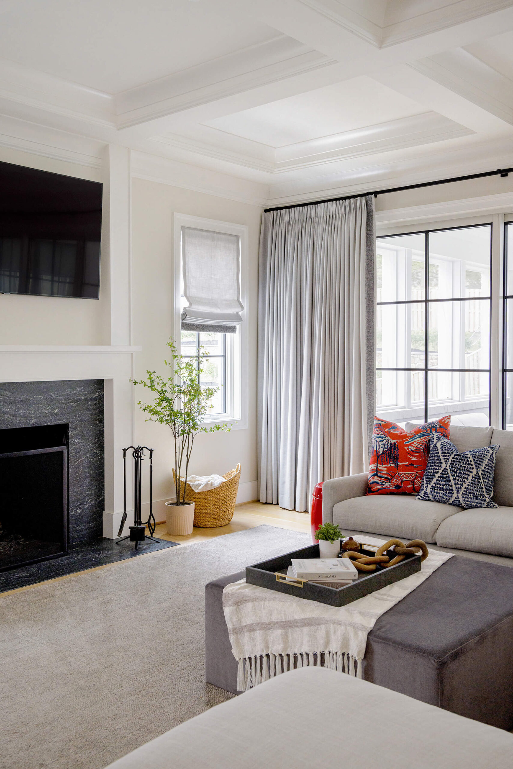 white coffer ceiling , transitional living room , red and blue accent pillows , elegant transitional design