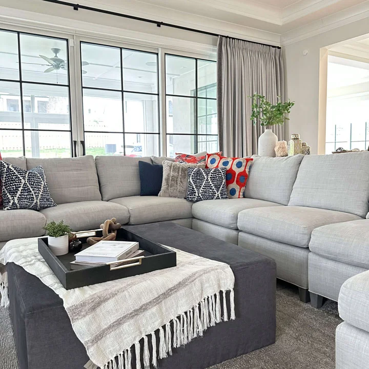 white coffer ceiling , transitional living room , red and blue accent pillows , elegant transitional design